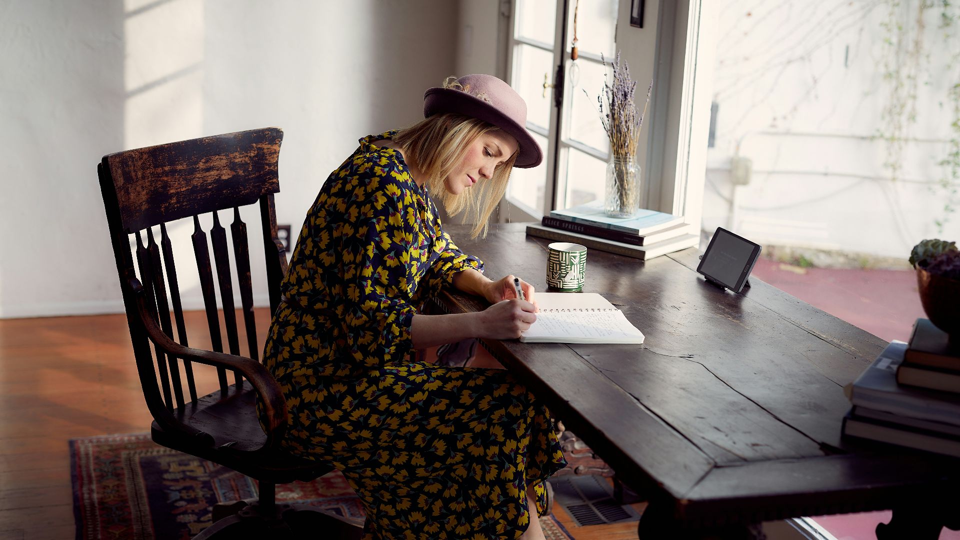 woman in yellow and black floral dress sitting on brown wooden chair