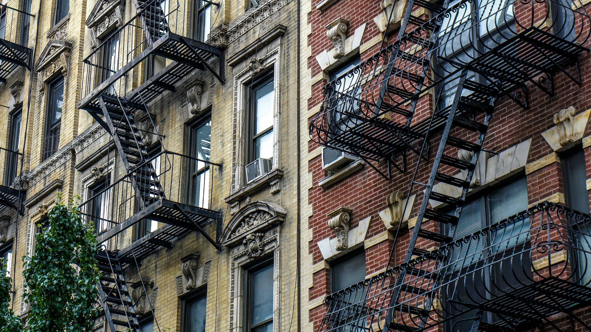 Apartment buildings with ornate fire escapes and air conditioners