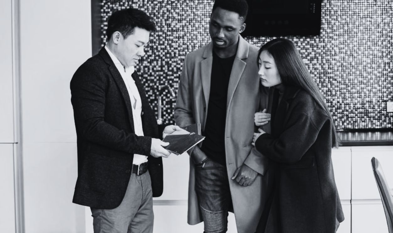 A business meeting in a contemporary kitchen showing diverse professionals discussing strategic options