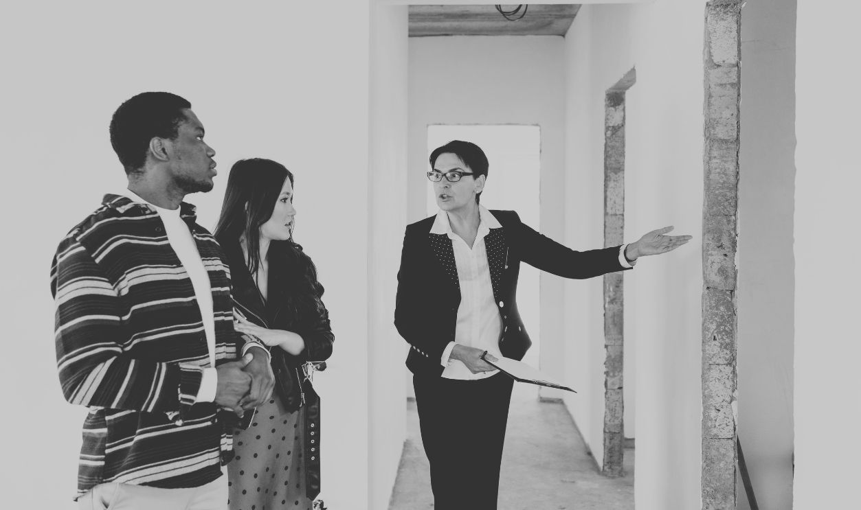 Real estate agent shows a house to a couple, discussing features