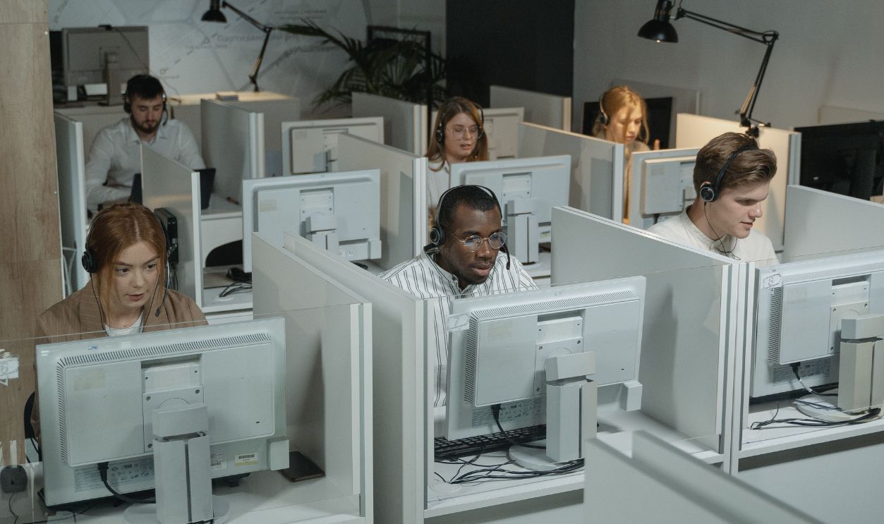 Professional customer support team working with headsets in a modern office