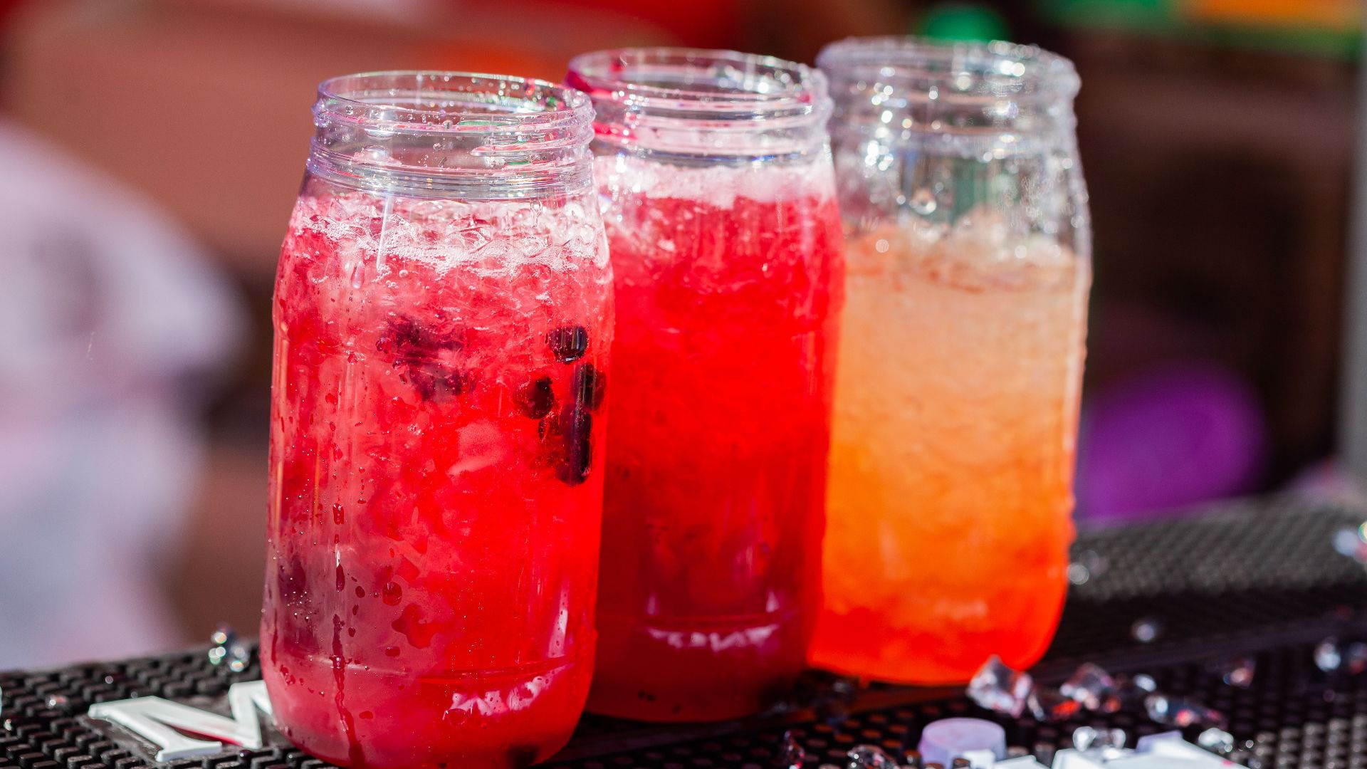 Three vibrant cocktails in glass jars, perfect for summer refreshment.