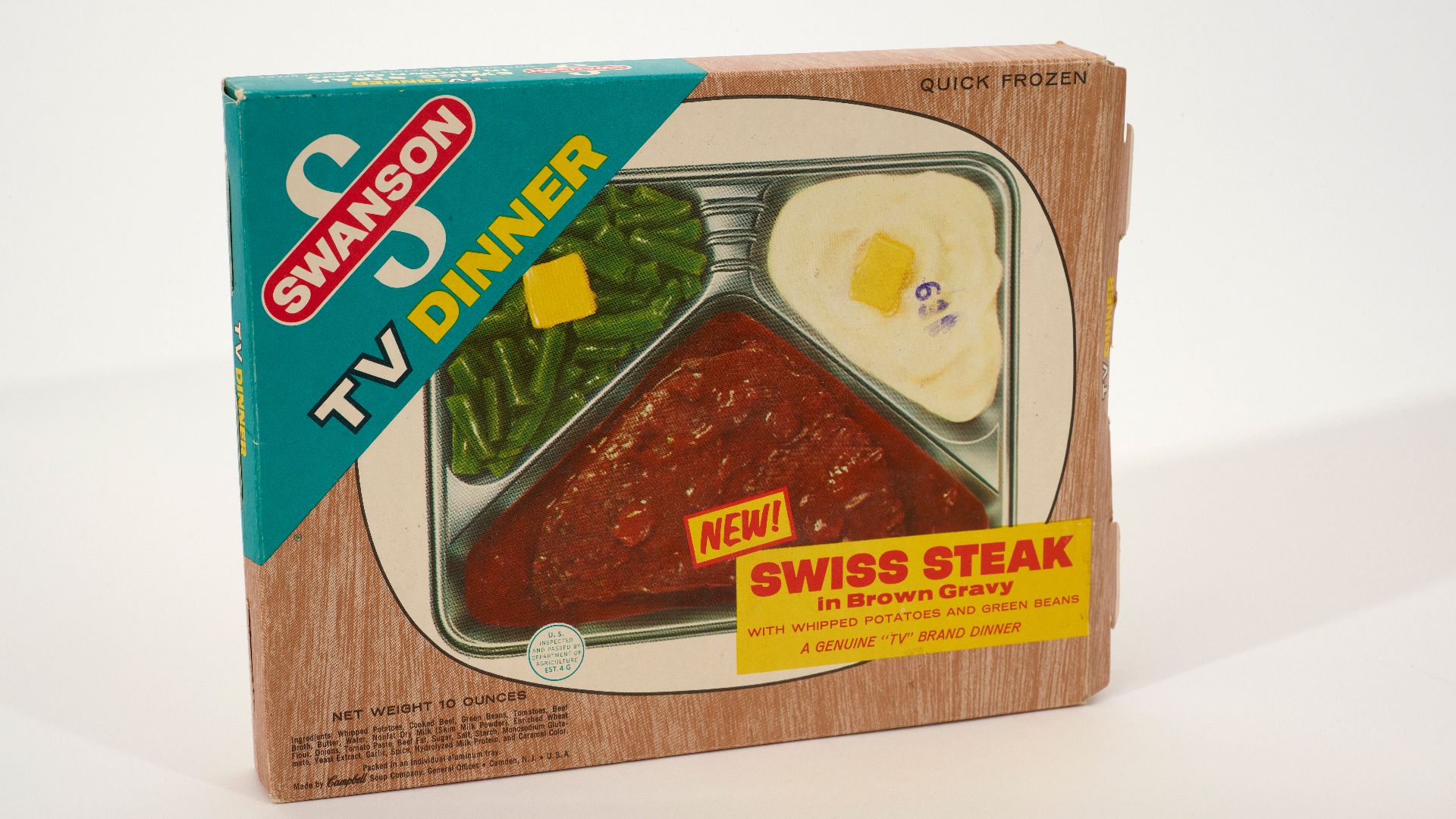 Swanson TV Dinner box and tray. The cardboard box features the Swanson logo and an image of Swiss Steak in brown gravy with whipped potatoes and green beans.