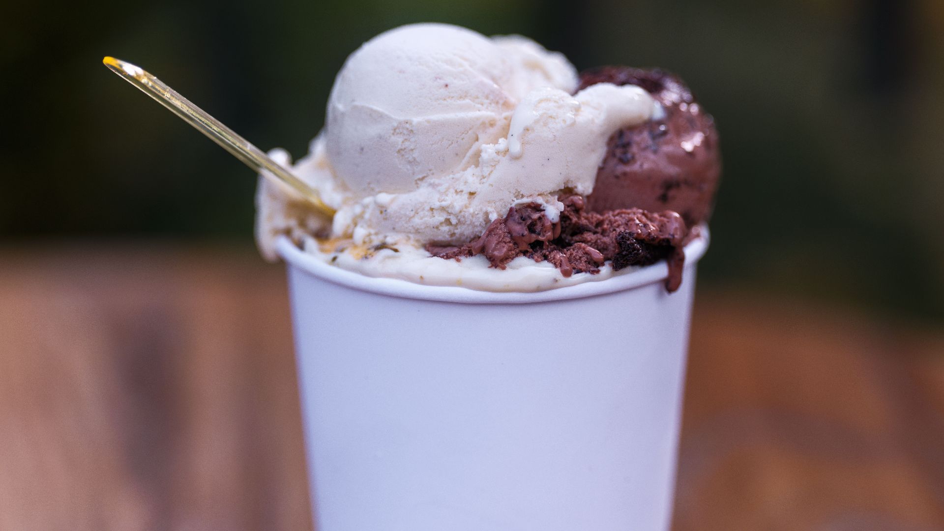 Close-up of vanilla and chocolate ice cream in a white cup with a spoon. Perfect summer dessert.