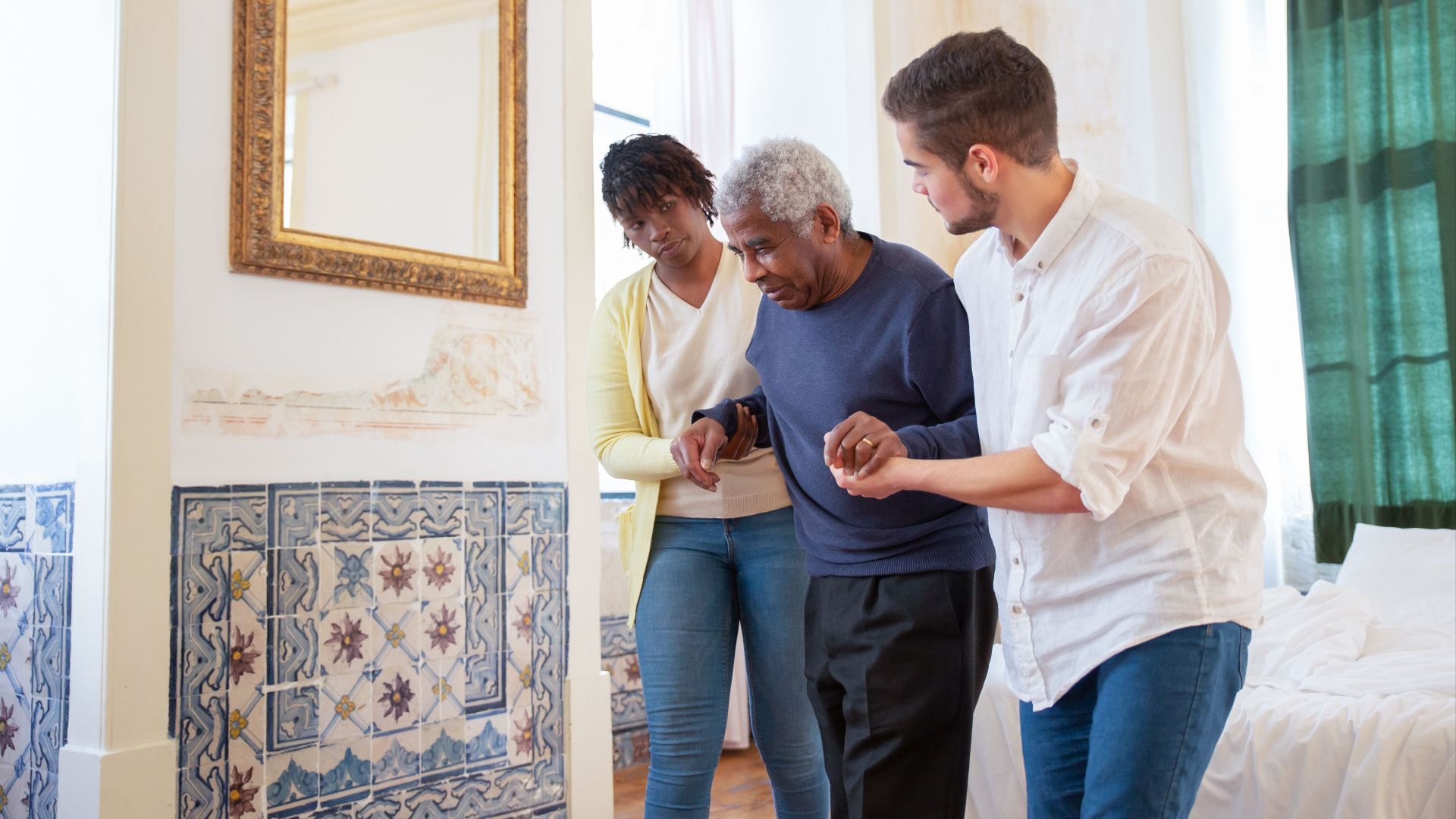 Elderly man receiving assistance in a beautiful room with traditional Portuguese tiles.