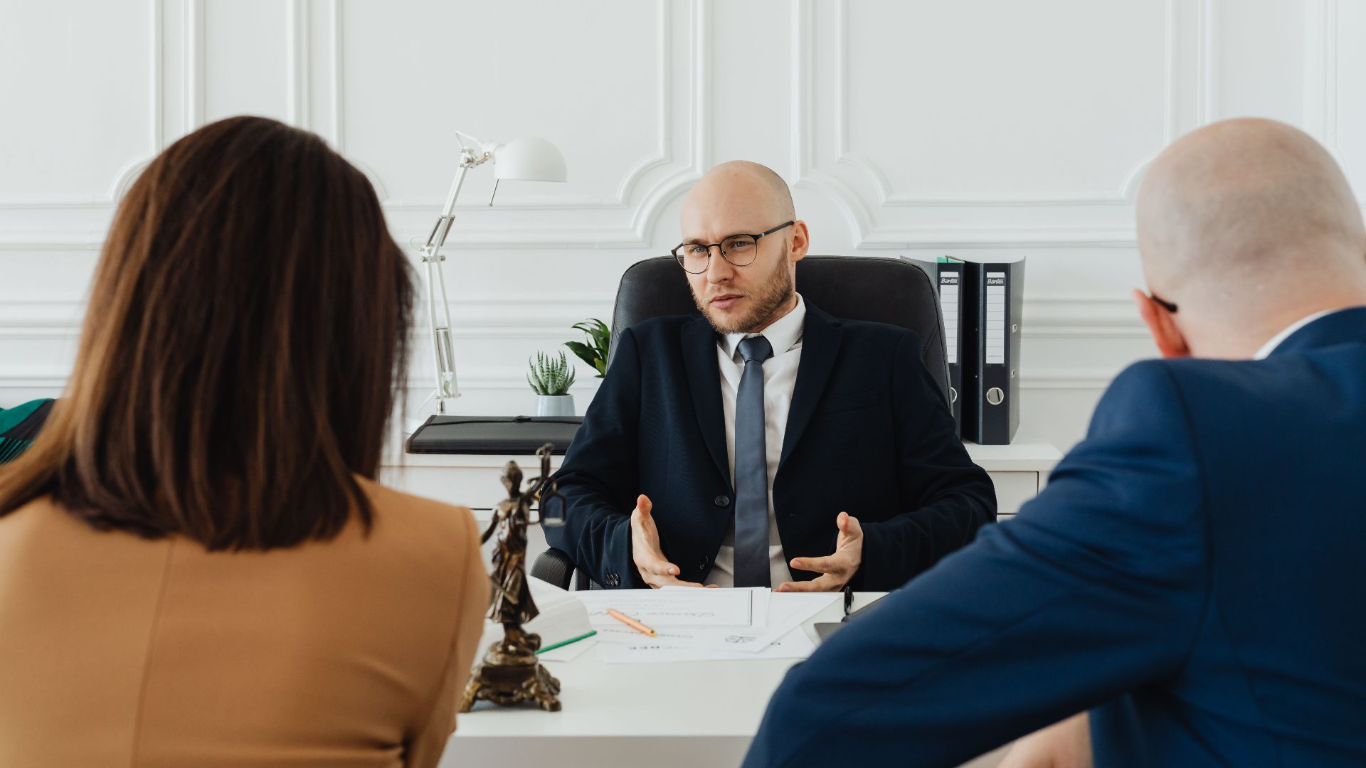 A professional business meeting with a lawyer and clients in a modern office setting.