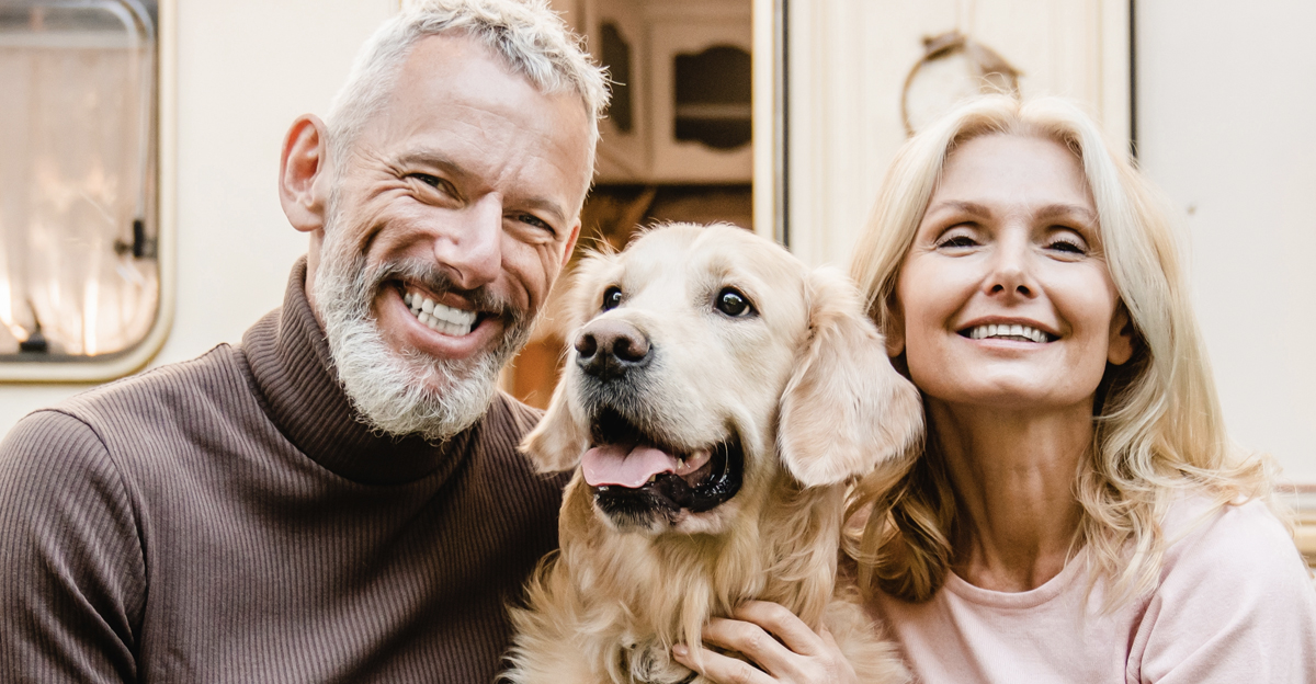 Happy senior caucasian couple spouses travelers explorers sitting in the garden near camper van trailer with their dog pet golden retriever with vegetables on the porch