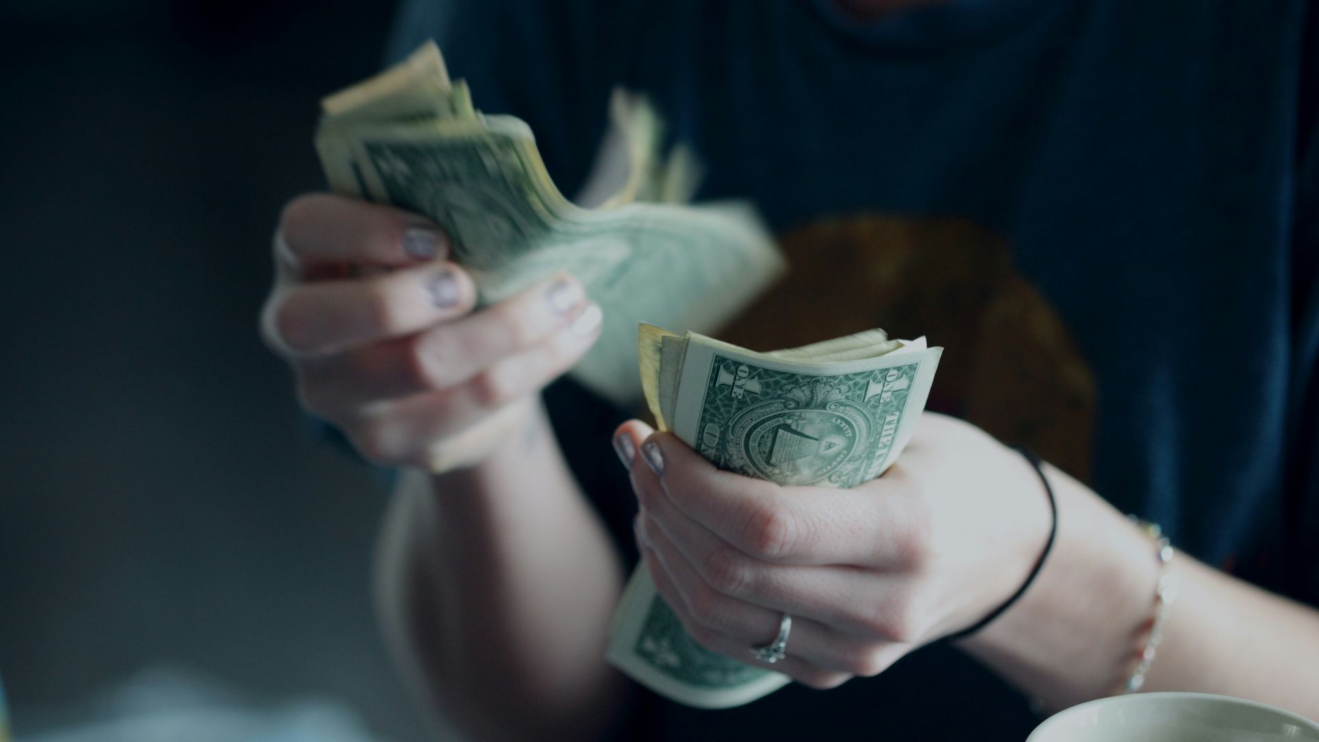 focus photography of person counting dollar banknotes
