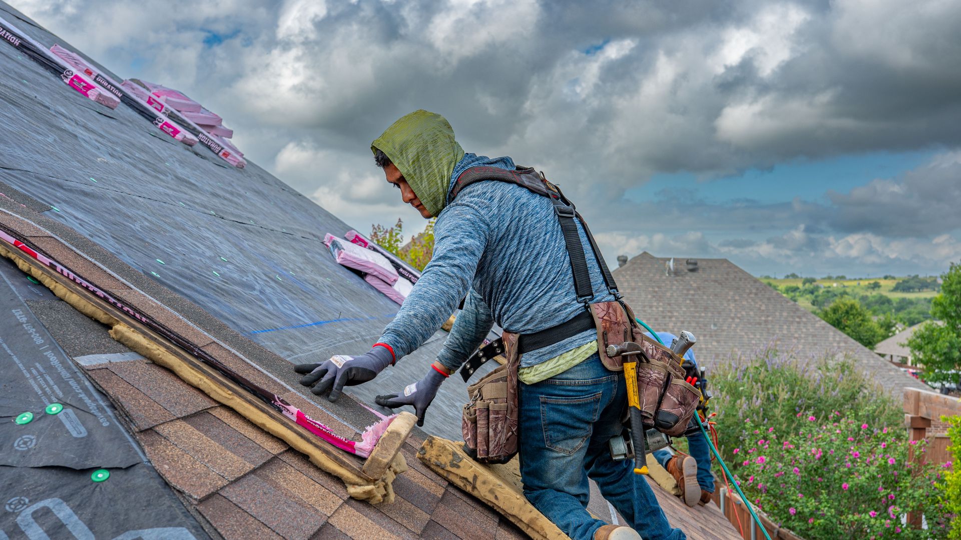 Roofers working on shingle installation on a home in Fort Worth, Texas under blue skies.