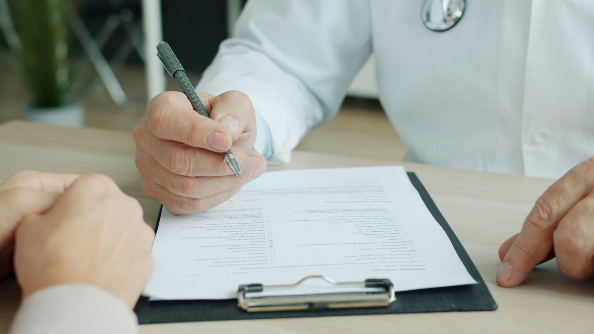 Doctor writing on a patient's chart