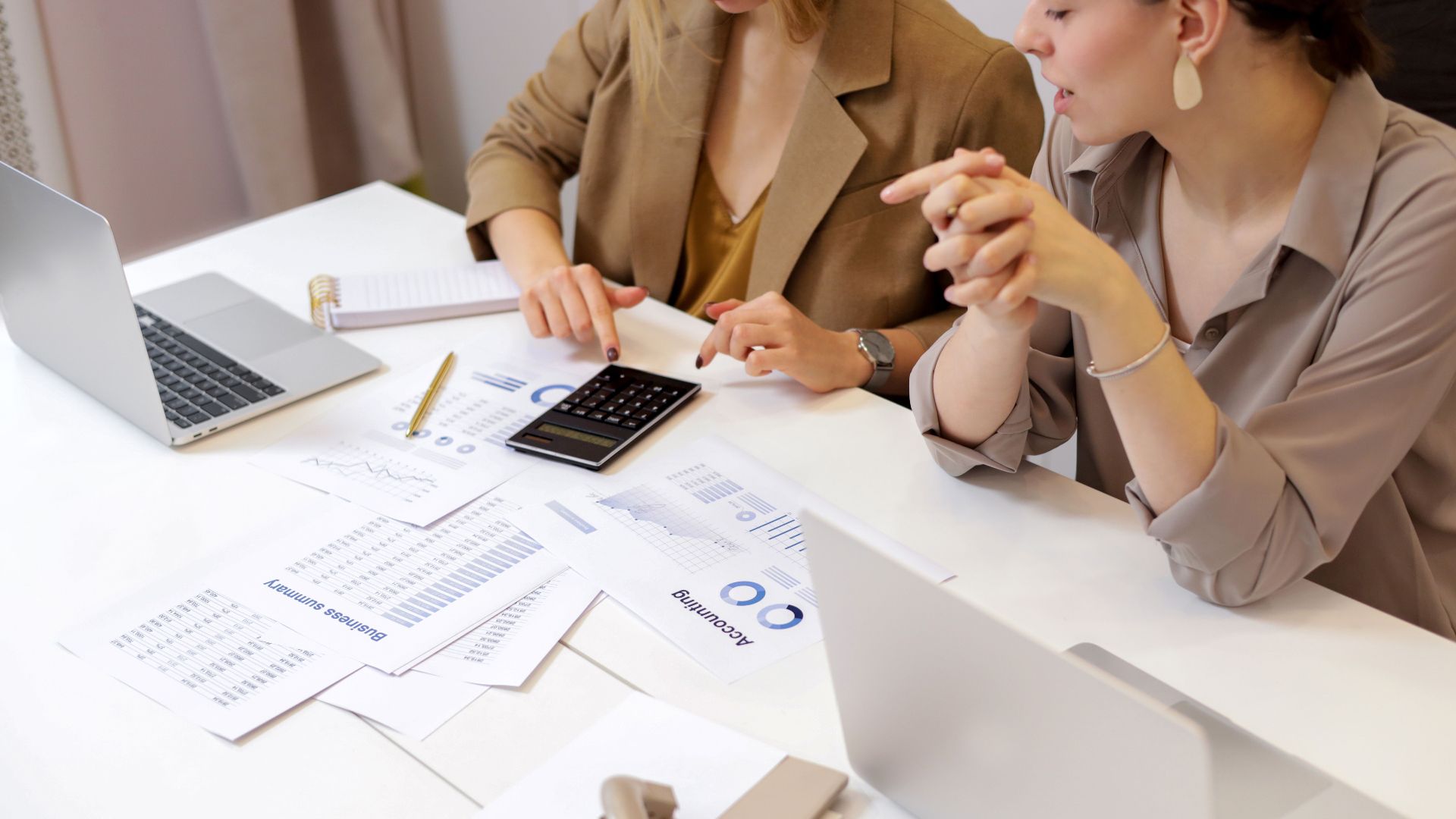 Two professionals collaborating on financial documents in a modern office setting.
