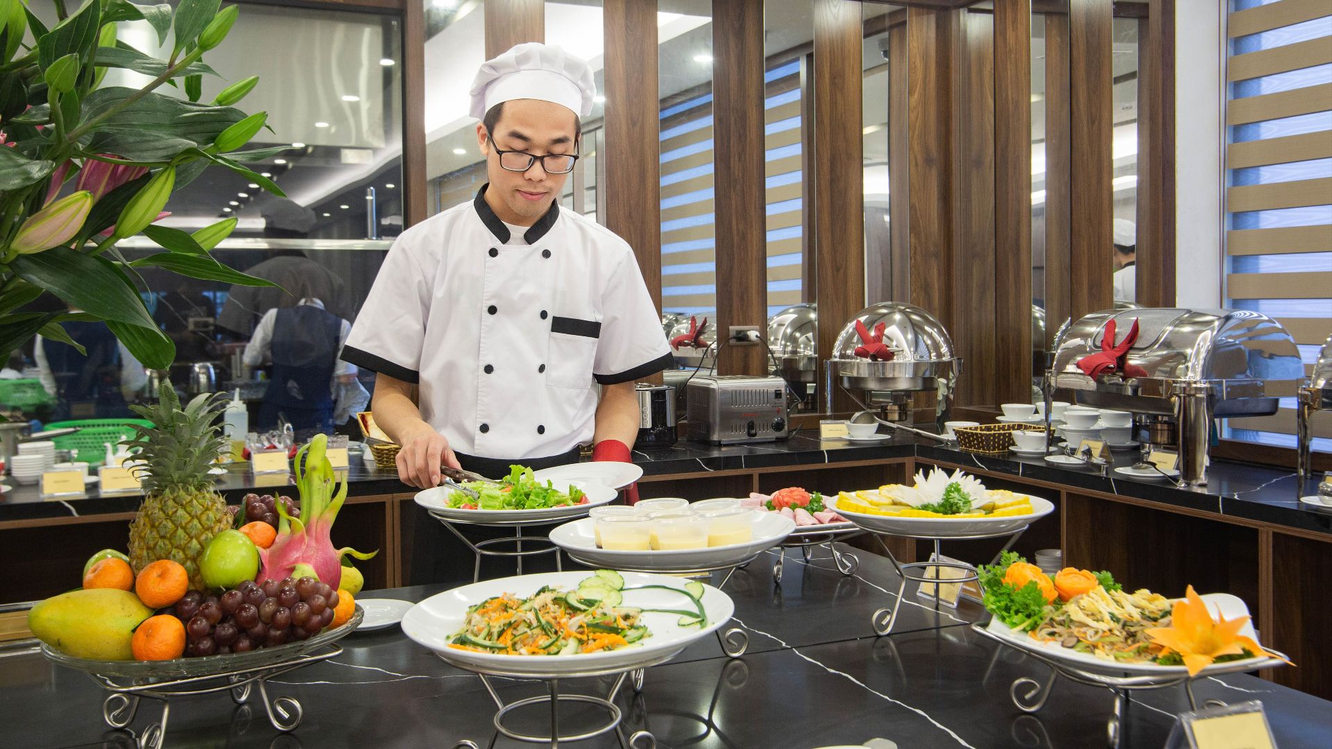 Chef preparing a buffet with various dishes at a hotel in Hanoi, Vietnam.