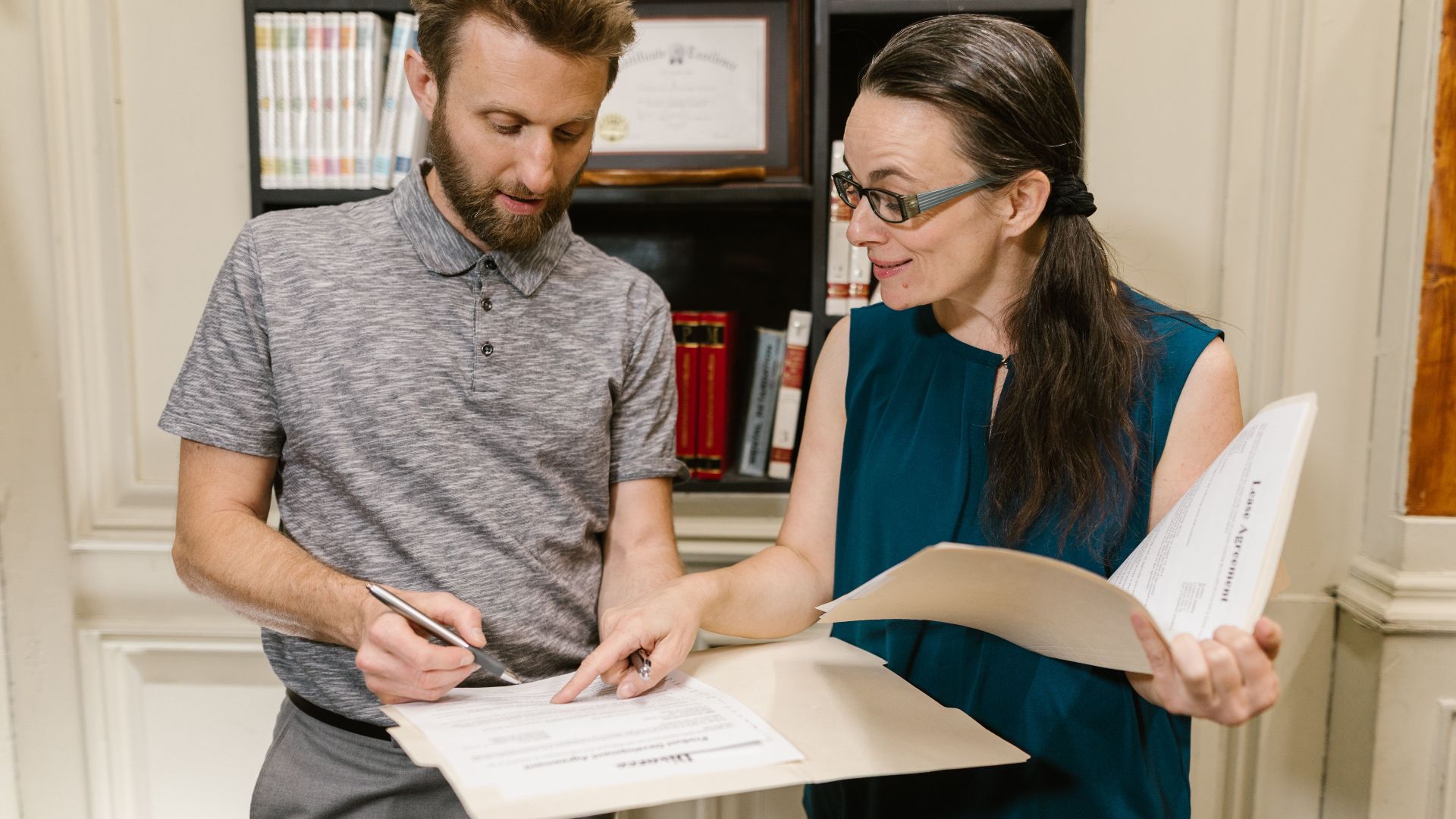 Two adults reviewing documents during a legal consultation in an office setting.