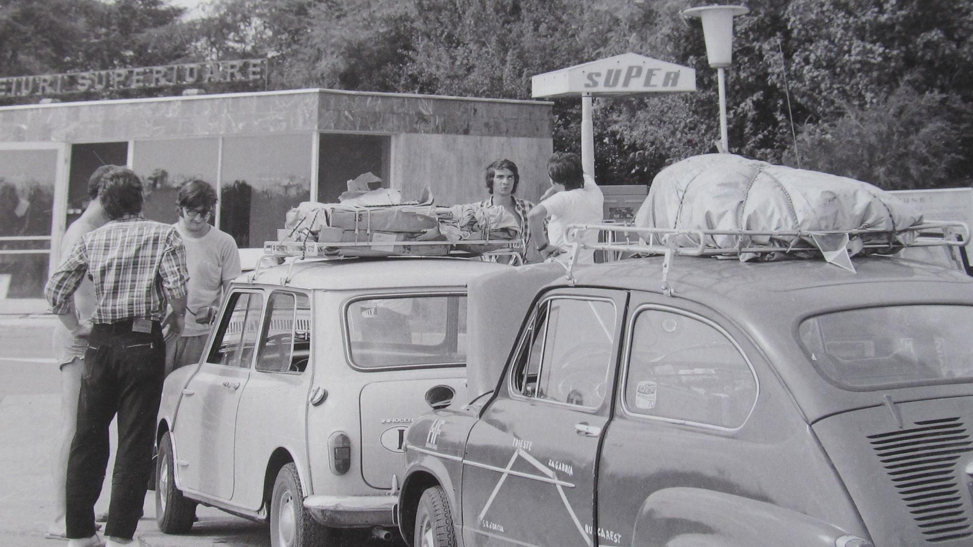 Italian tourists visiting Romanian seaside in 1973, shown here next to their Innocenti Mini and Fiat 600 cars in a petrol station in Aurora, Romania. The picture is part of the