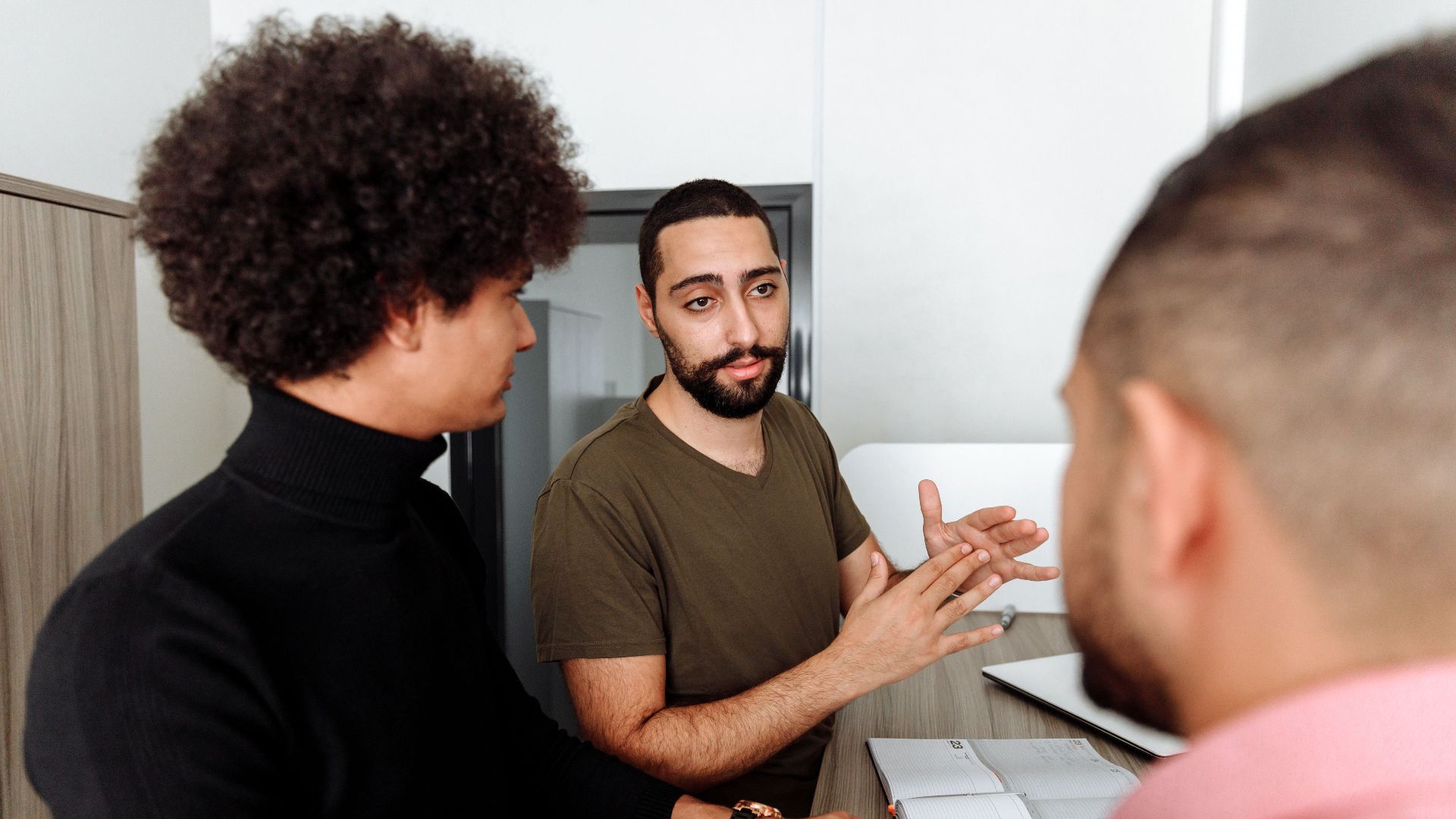 Group of colleagues having a thoughtful discussion in a modern office setting.