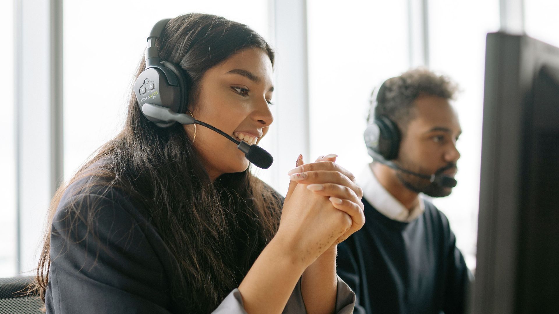 Customer service team working in a modern office with headsets.