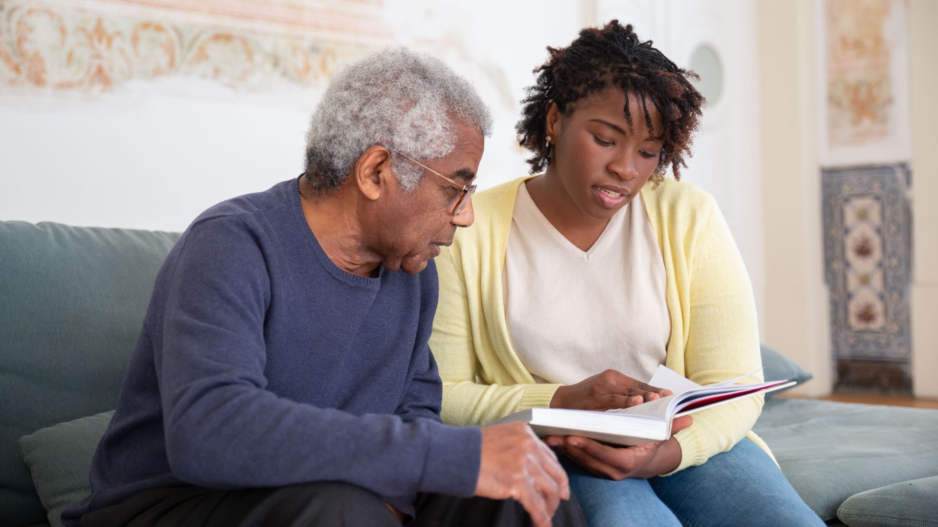 A senior man and caregiver engage in a meaningful conversation at home.