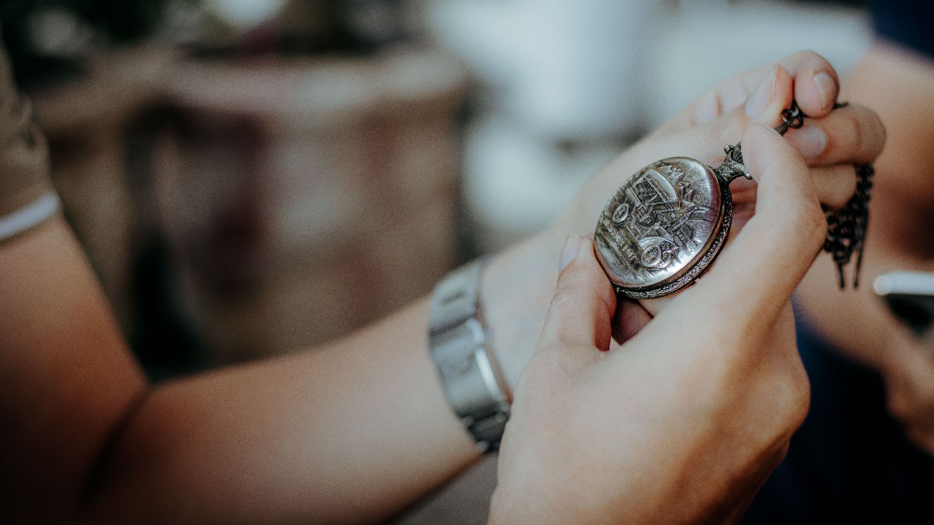 Intricate antique pocket watch held in hand. Detailed close-up showing vintage timepiece.
