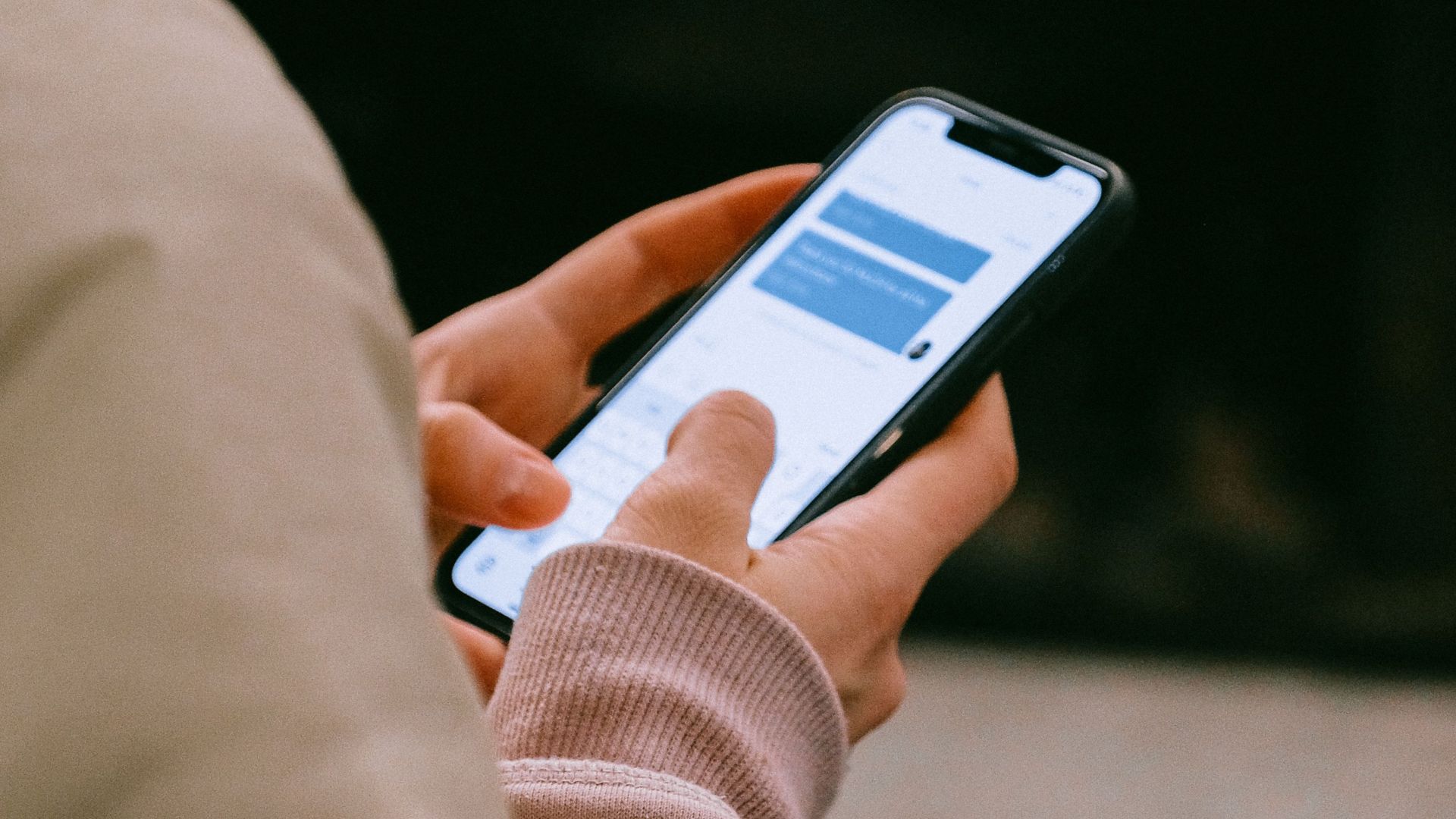 A person using a smartphone for texting, focusing on their hands and device screen.