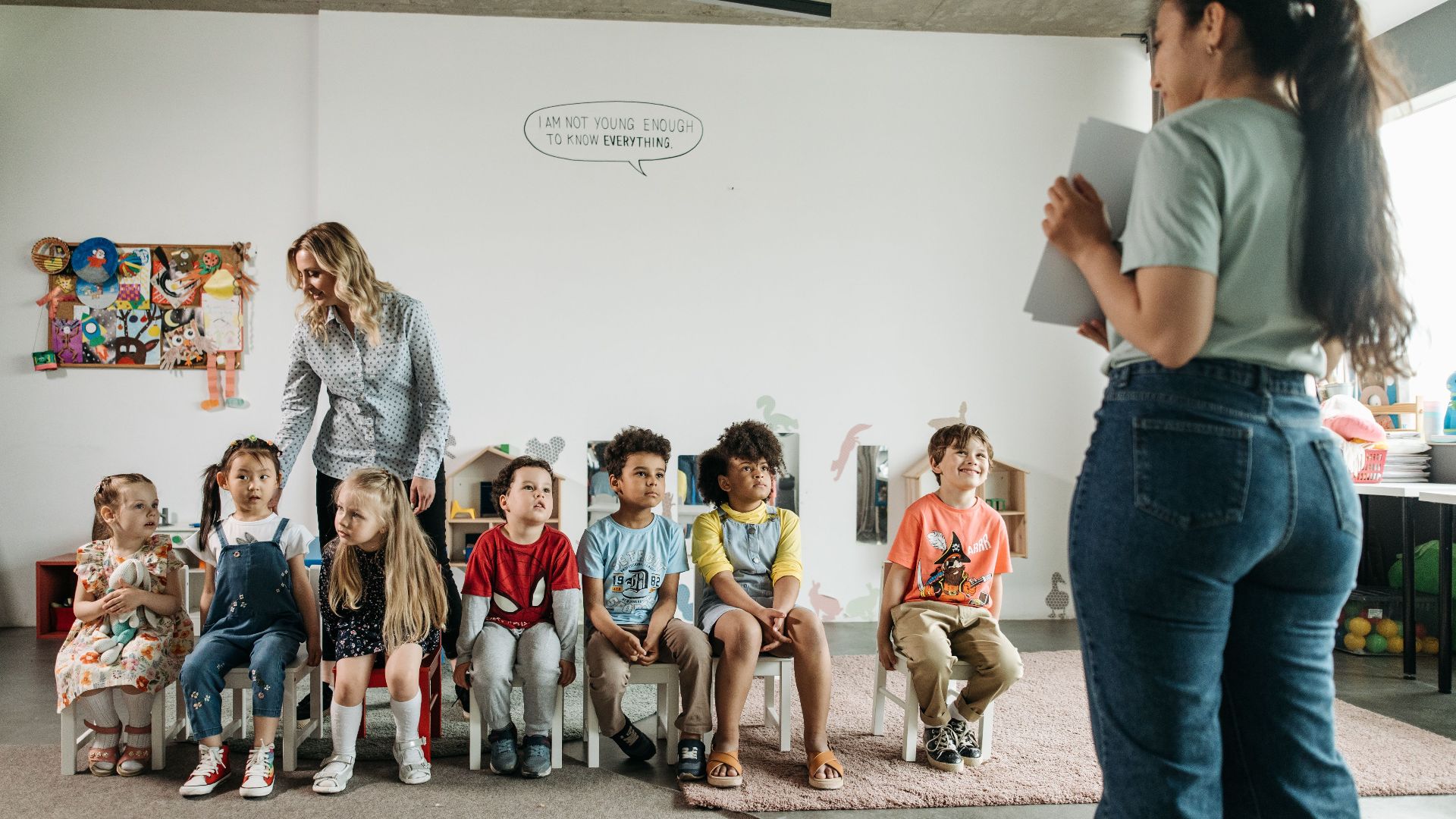 Diverse group of preschool children and teachers in an engaging classroom setting.