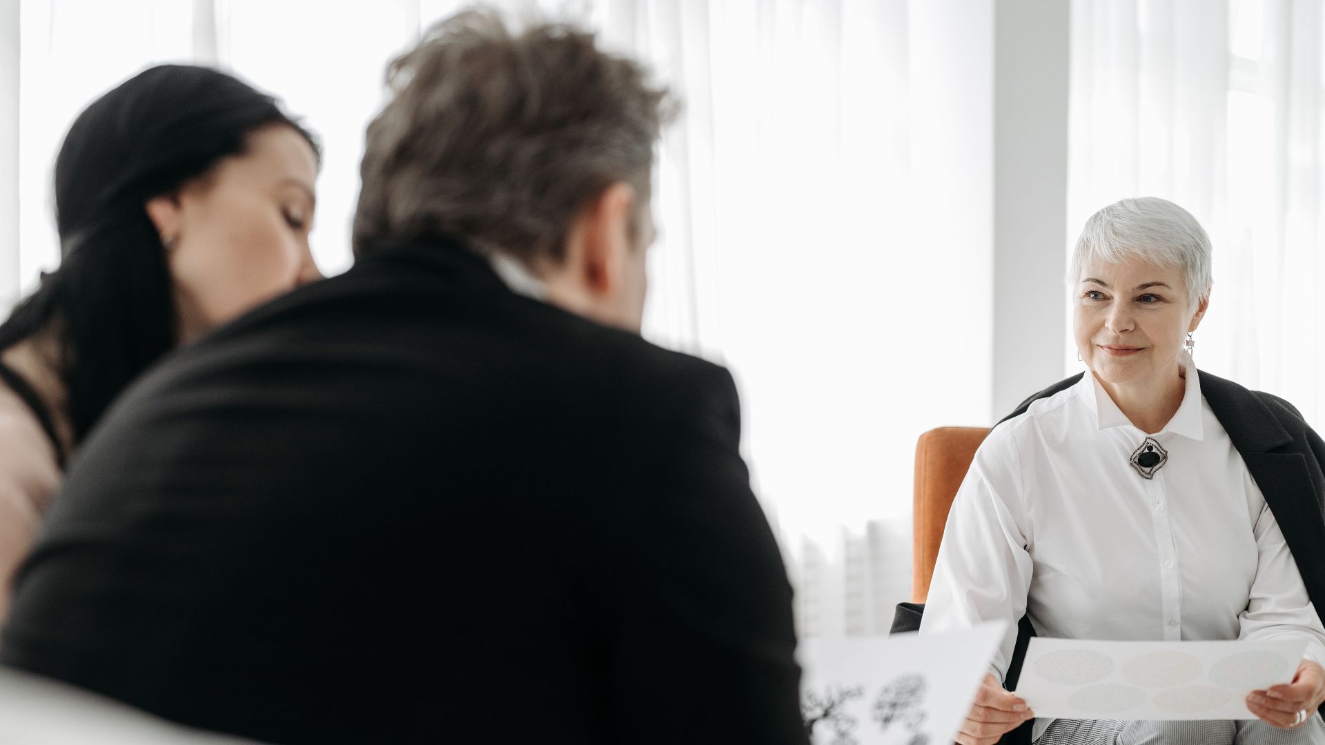 A diverse group engaged in a professional consultation in a modern, well-lit office setting.