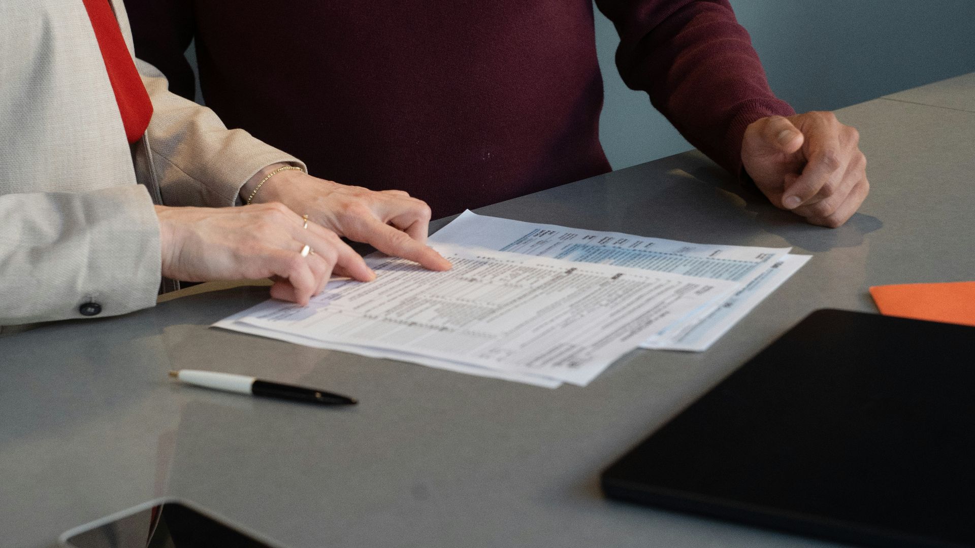 Two people reviewing documents at a table.