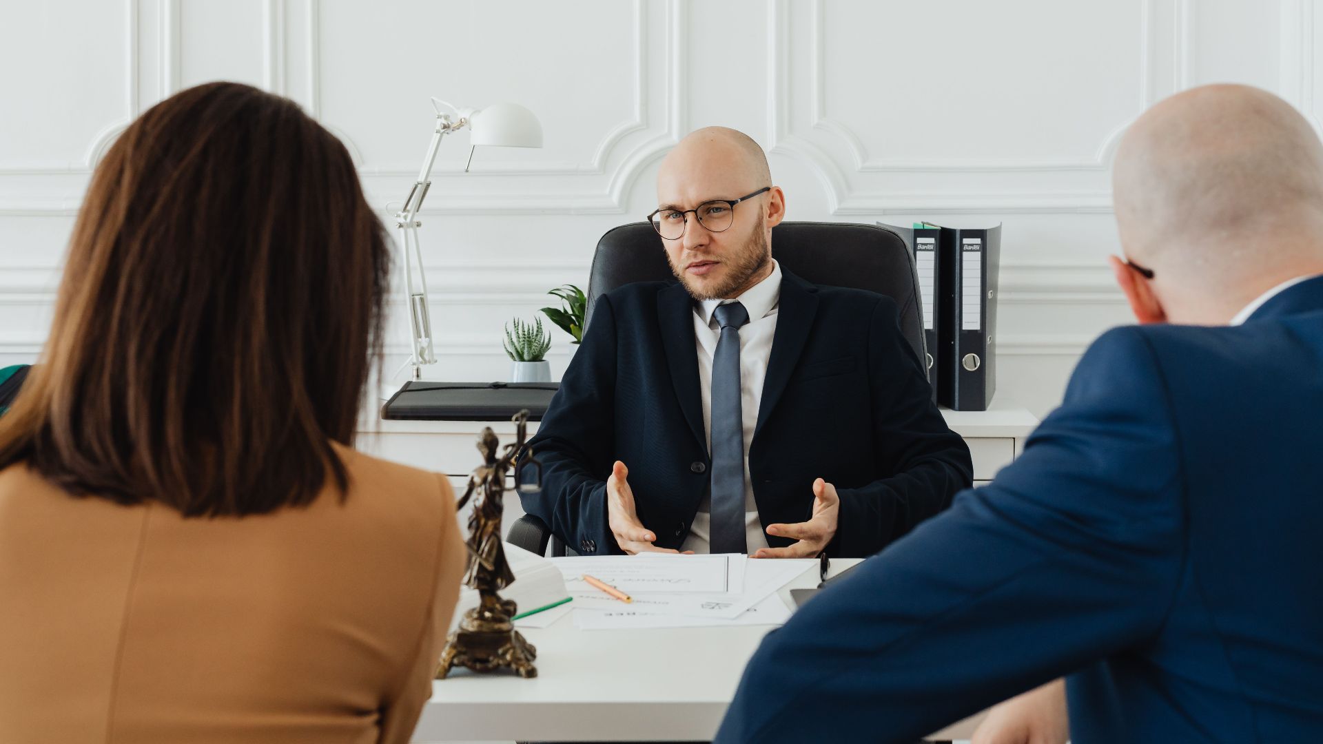 A professional business meeting with a lawyer and clients in a modern office setting.