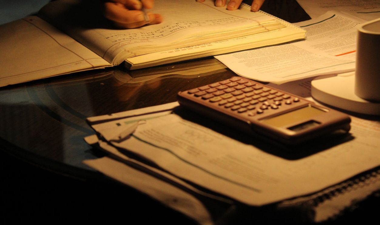 A focused study session at night with open books and a calculator on a dimly lit table