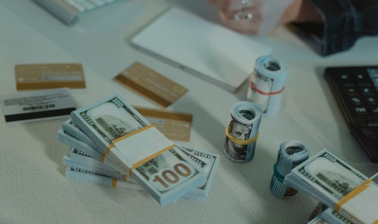 Close-up of dollar bills and credit cards on a desk, symbolizing financial transactions