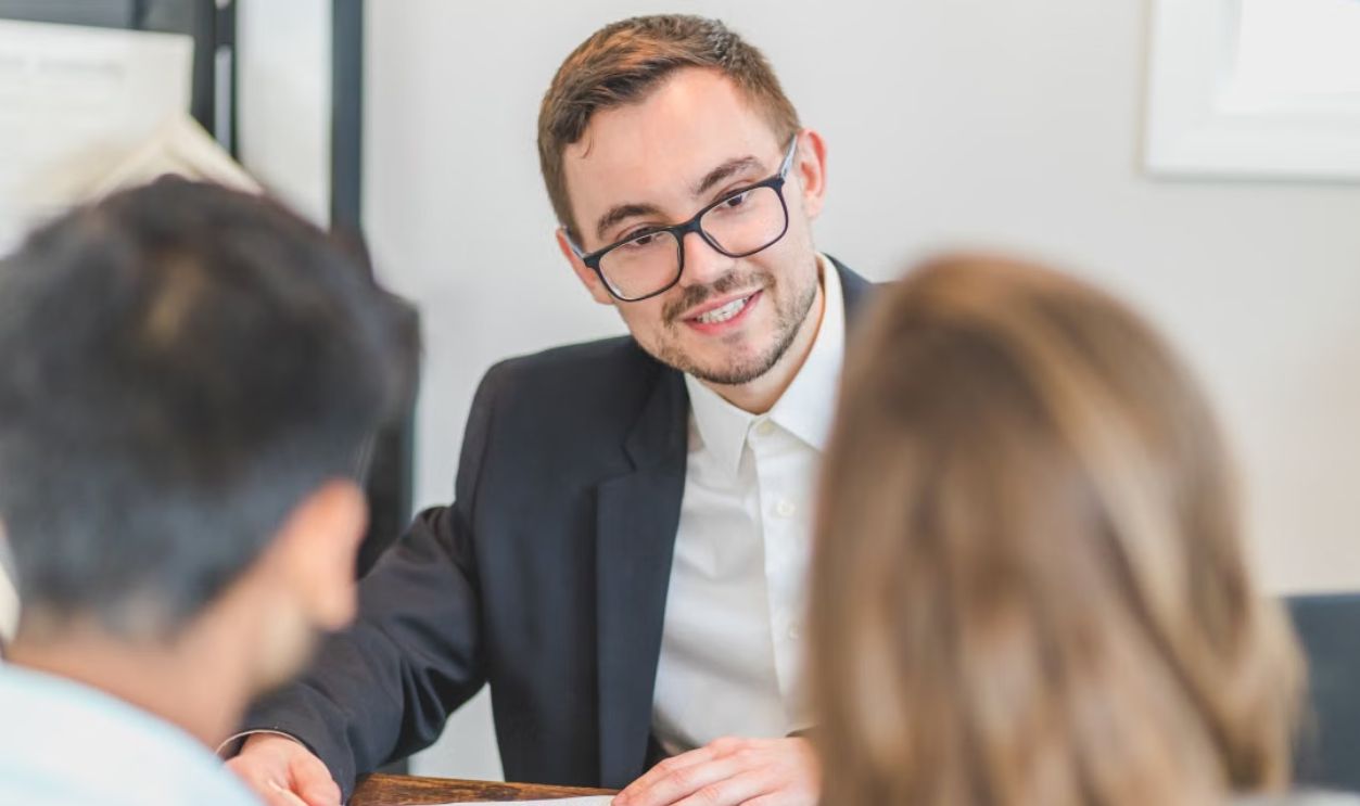 Smiling businessman in a suit and eyeglasses during a team discussion