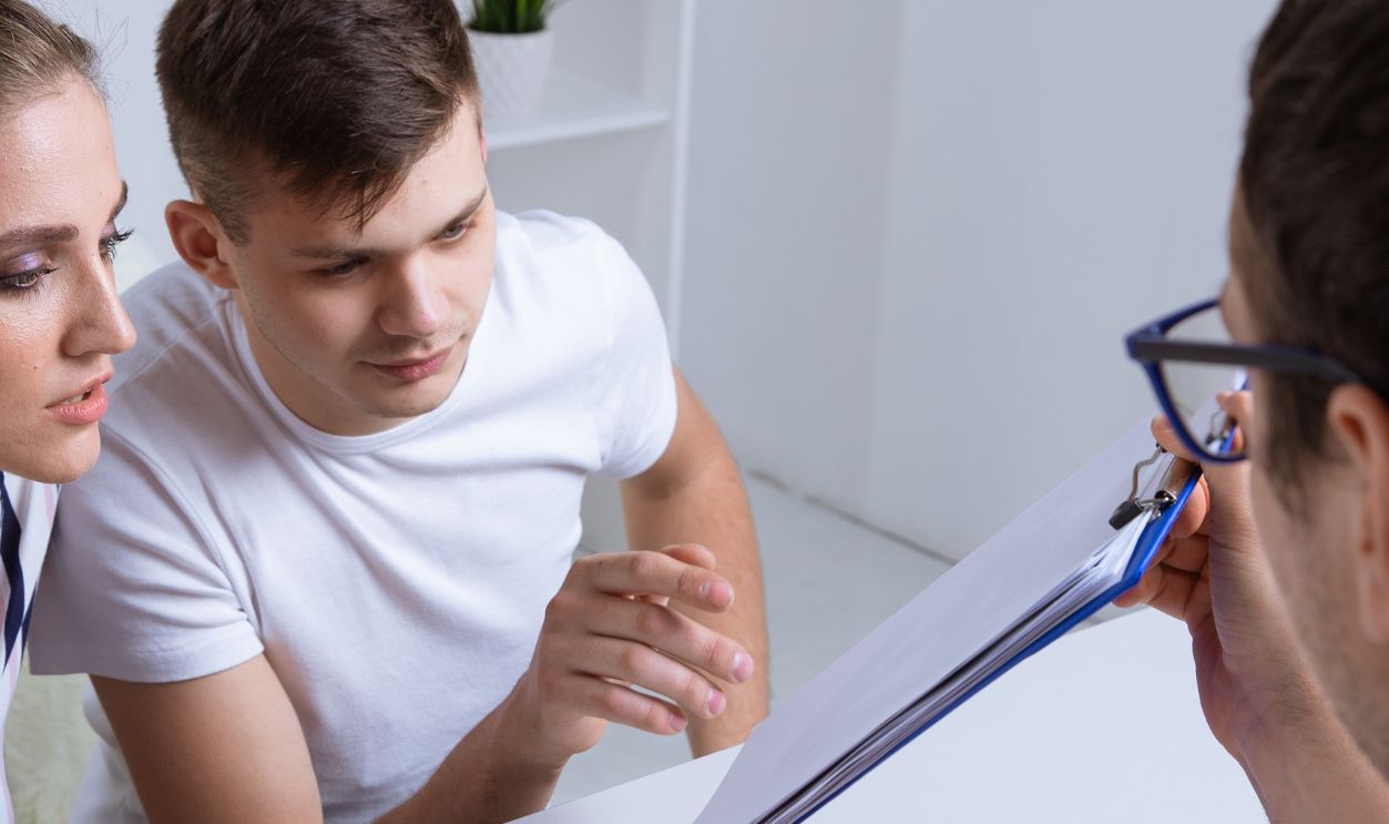 Young couple in process of documenting mortgage.