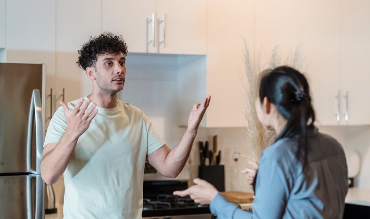 A couple in a tense conversation in a modern kitchen, expressing emotions