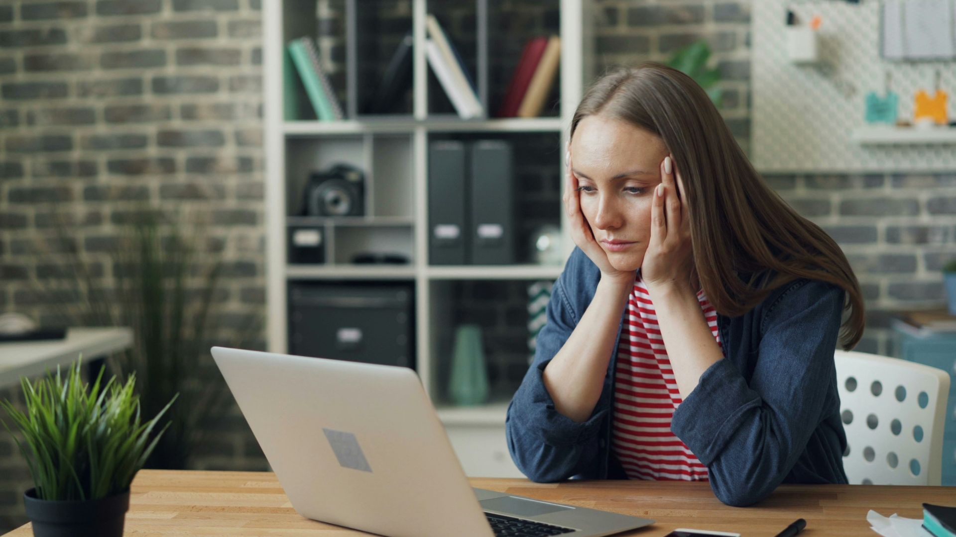 a woman sitting at a table with a laptop in front of her