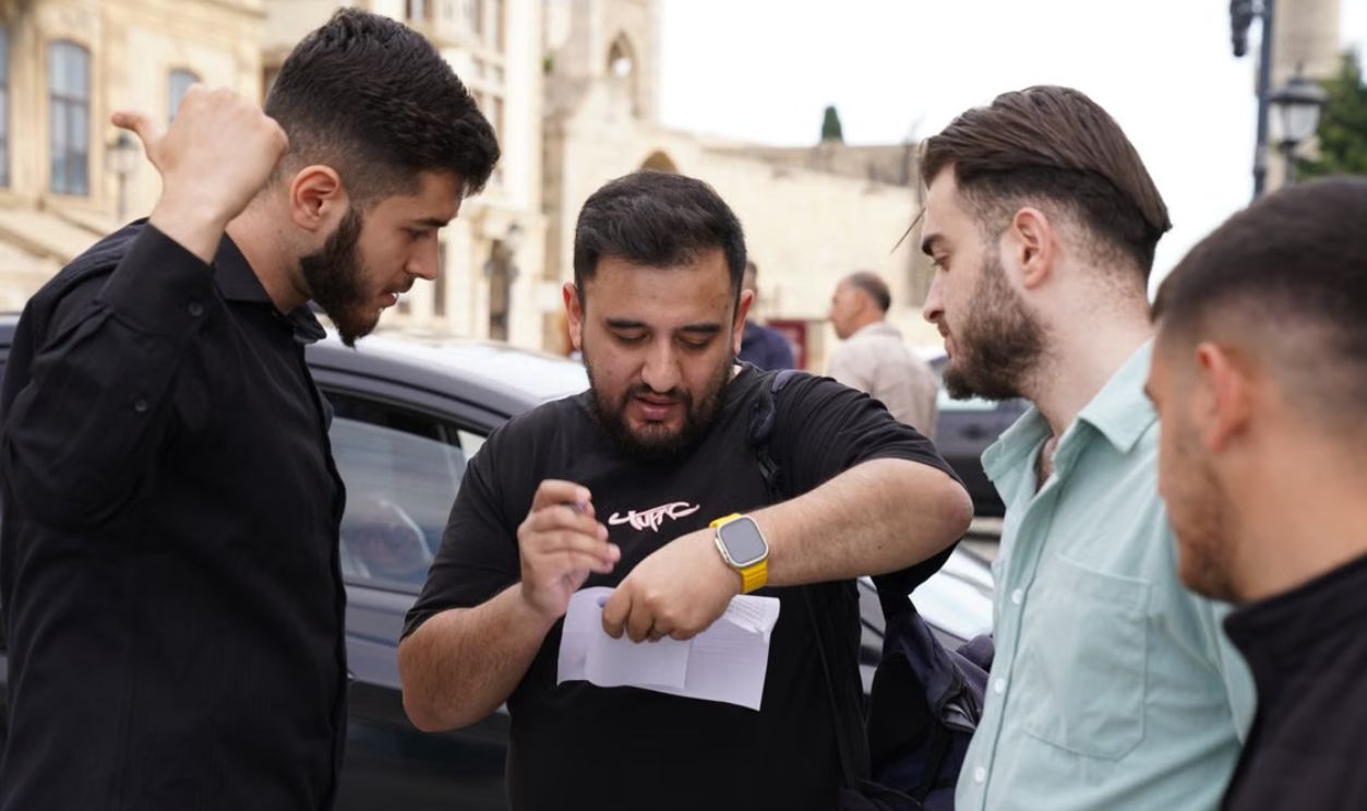 Four men engaged in conversation on a city street, displaying teamwork and collaboration