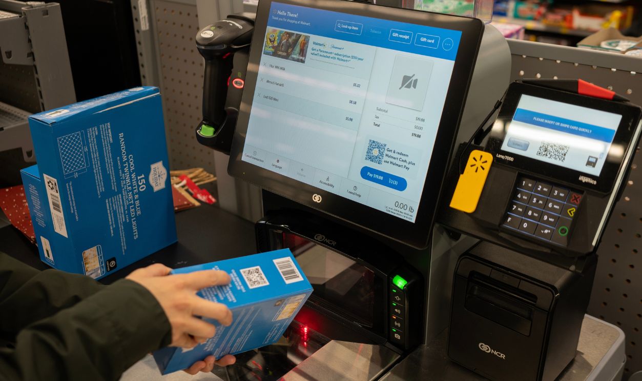 Tigard, OR, USA - Dec 5, 2023: A shopper scans a product barcode on packaging at the self-checkout lane in a Walmart Supercenter in Tigard, Oregon.