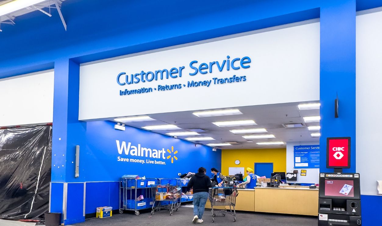 Calgary, Alberta, Canada. May 26, 2026. Wide-angle shot of customers at a Walmart customer service desk next to a CIBC bank ATM machine.
