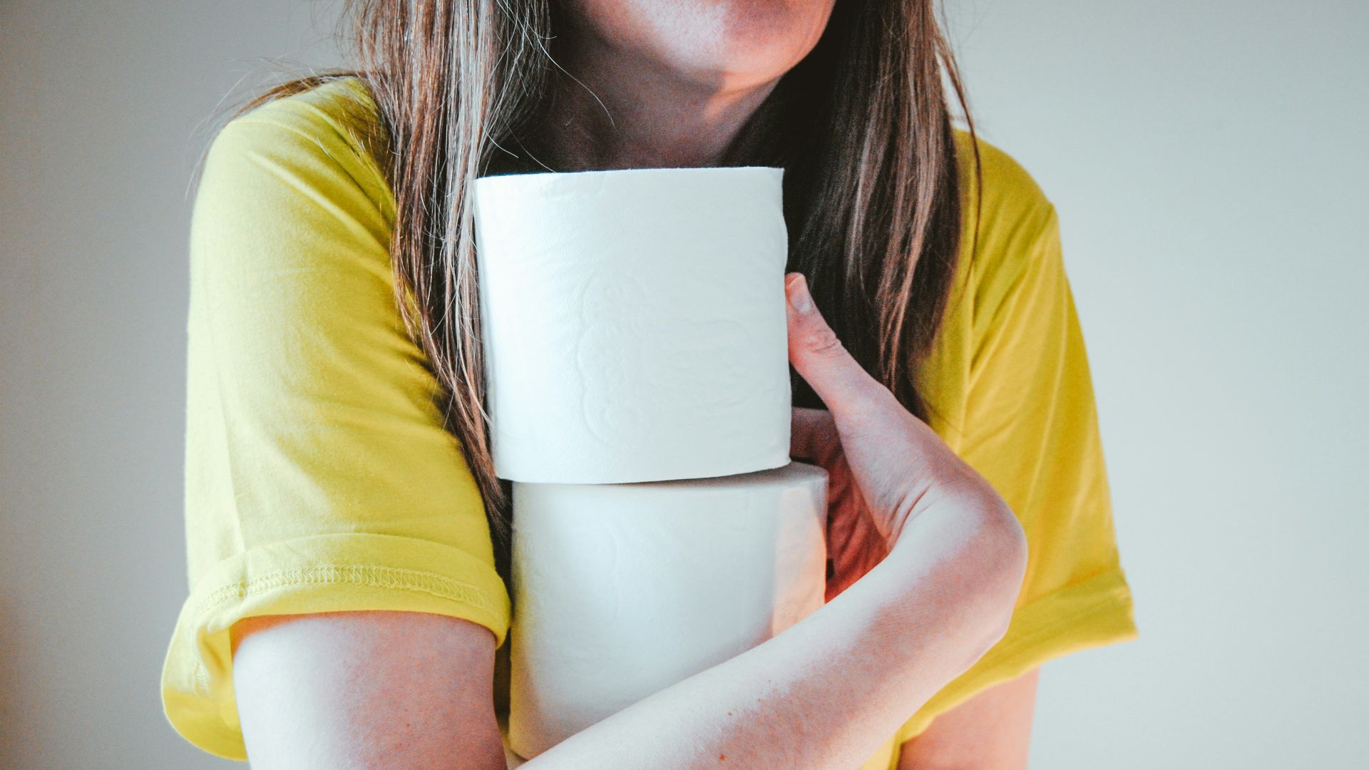 woman in yellow t-shirt holding white tissue paper