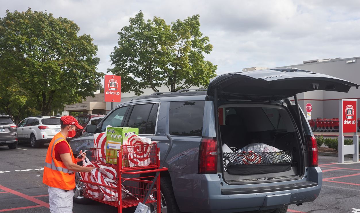 Tigard, OR, USA - Sep 19, 2020: A Target store employee brings bagged items out to a customer's car parked in the drive-up area outside the Target Tigard store during the coronavirus pandemic.