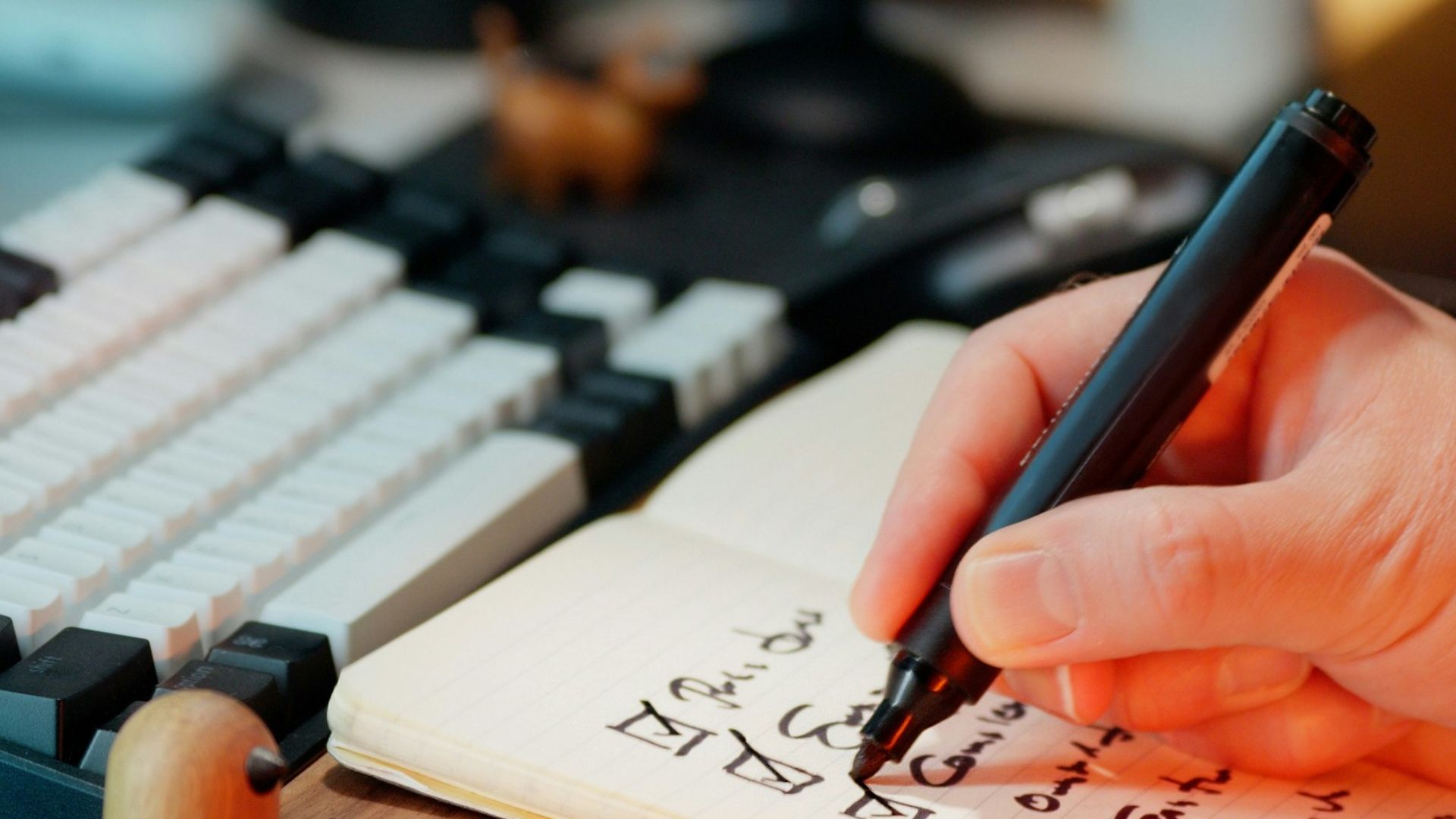 Someone is writing in a notebook with checkboxes.