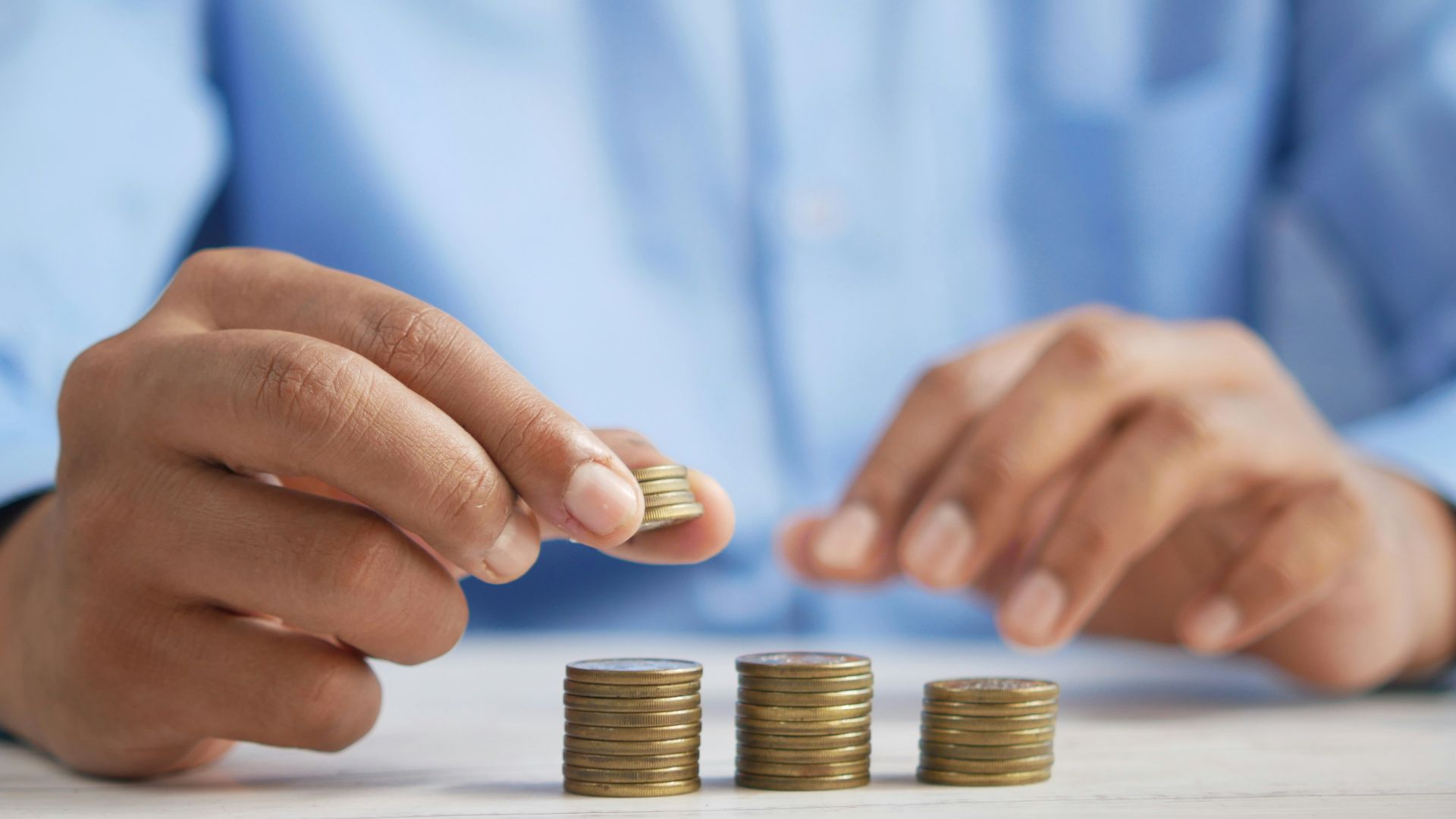 a person stacking coins on top of a table