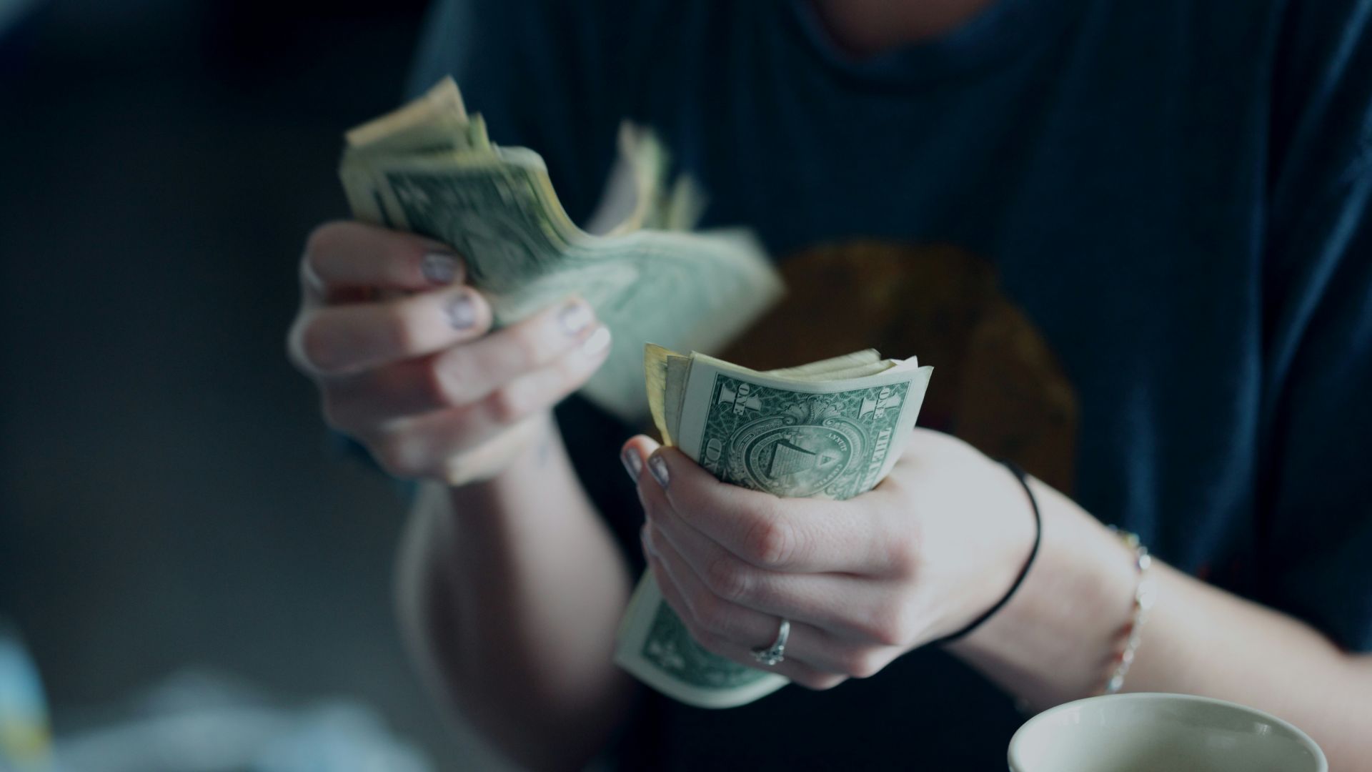 focus photography of person counting dollar banknotes