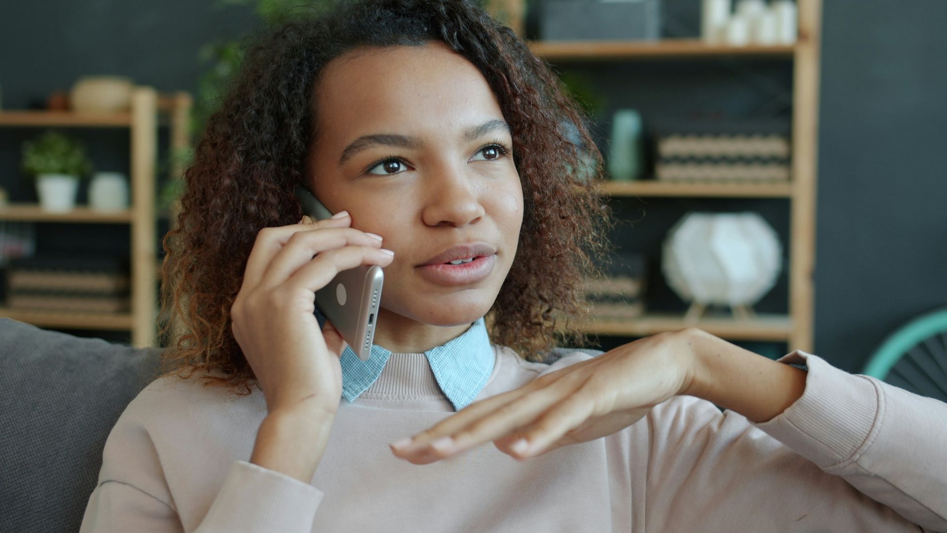 Young woman talking on a smartphone at home