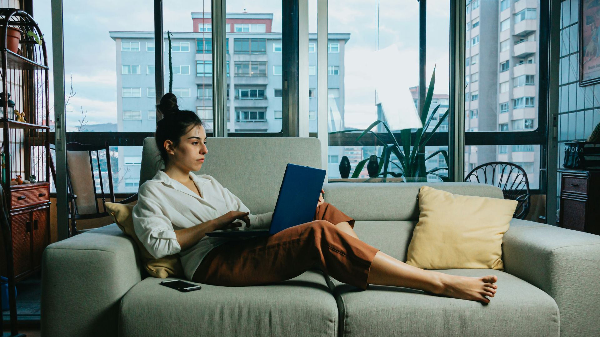 woman in white long sleeve shirt sitting on white couch