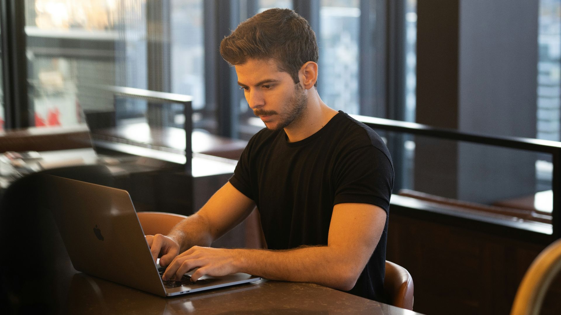 man in black crew neck t-shirt using macbook