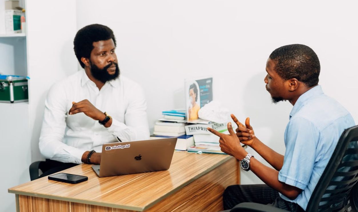 Two adults engaged in a professional consultation in a Lagos office, discussing business or healthcare topics.