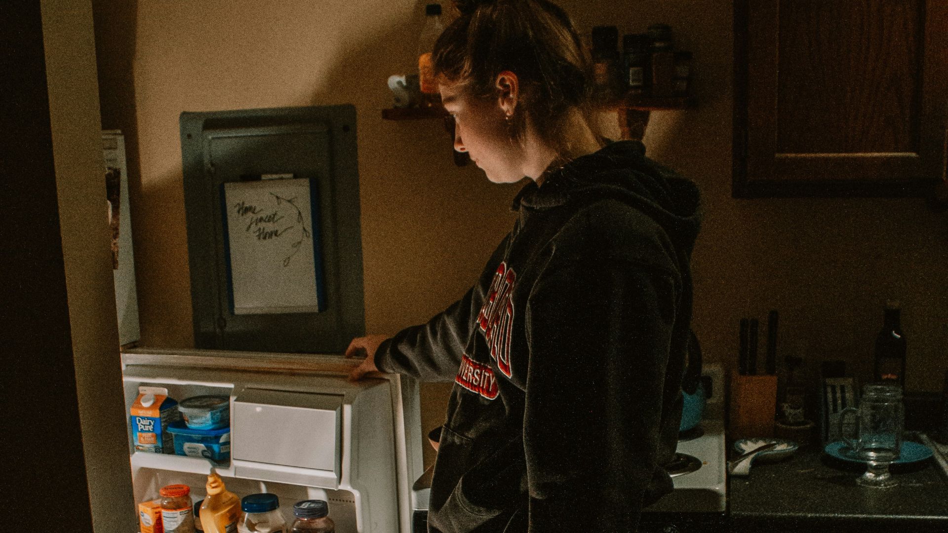 a person stands in front of a refrigerator