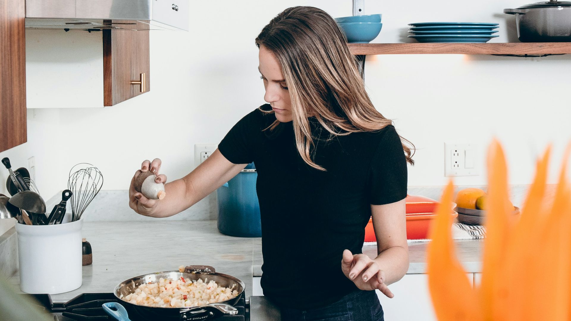 woman standing in front of freestanding range oven