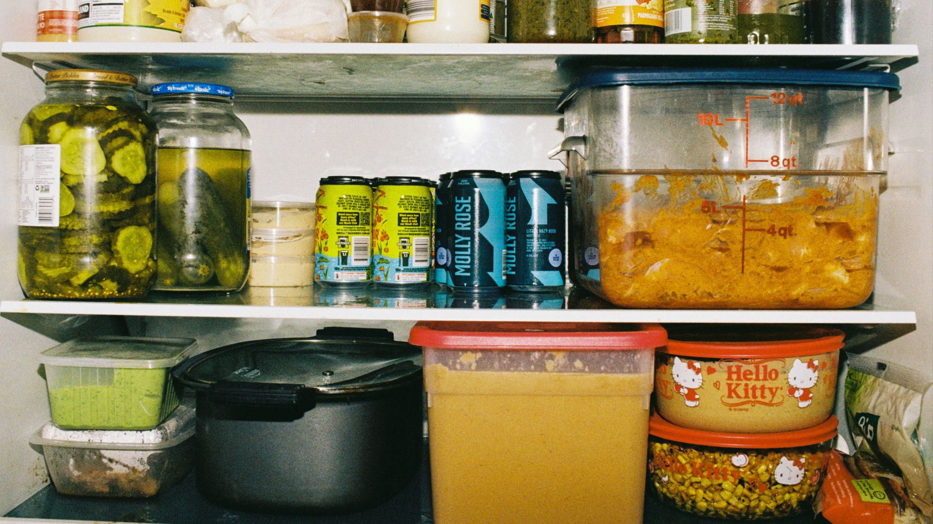 Refrigerator shelves packed with jars, cans, and food containers.