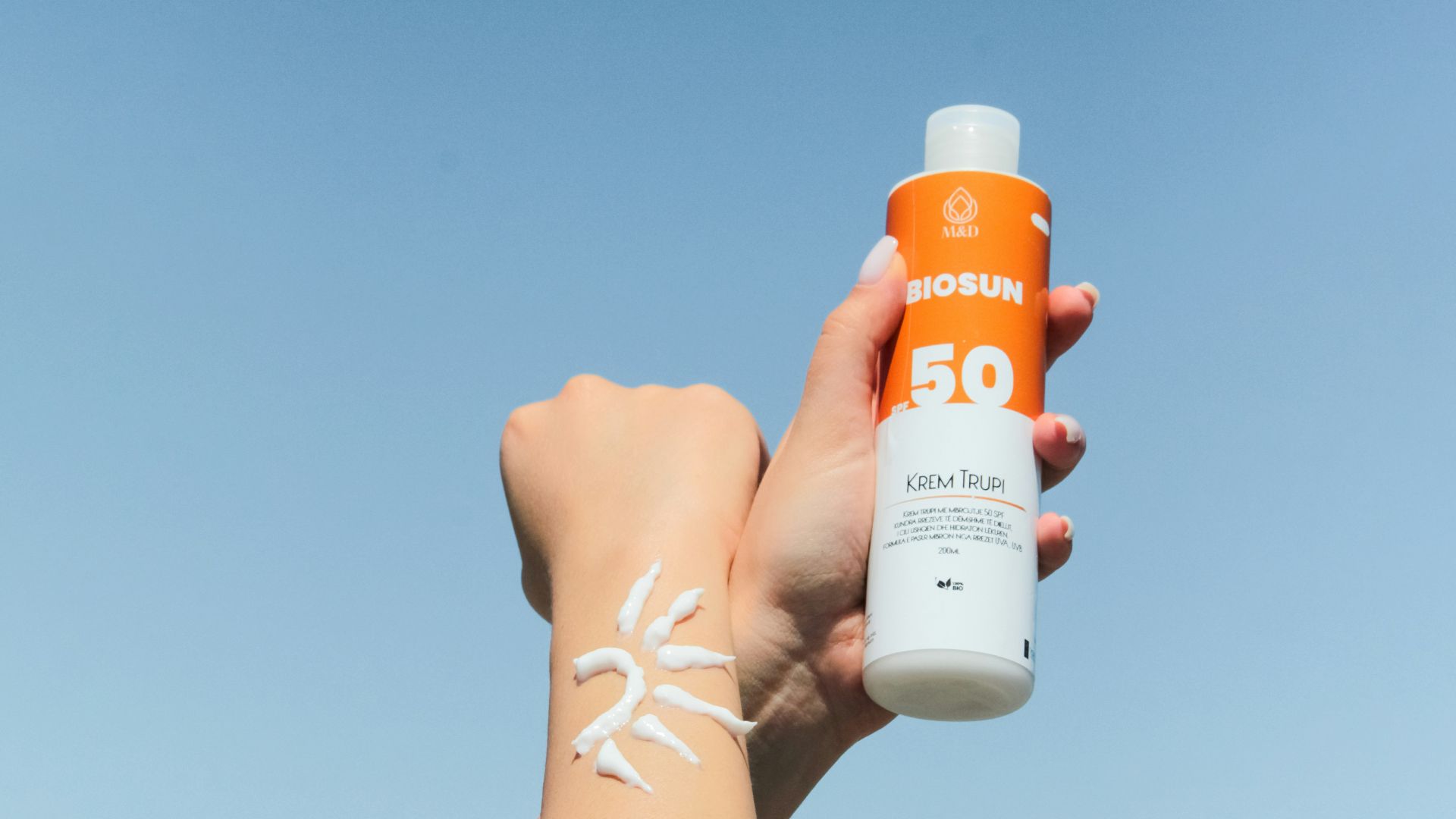 a person holding a bottle of sunscreen in their hand