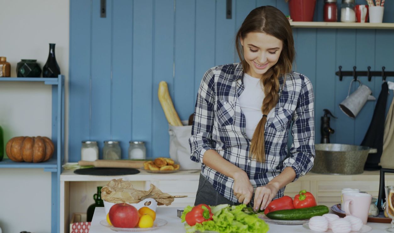 Smiling woman chopping vegetables in a cozy kitchen